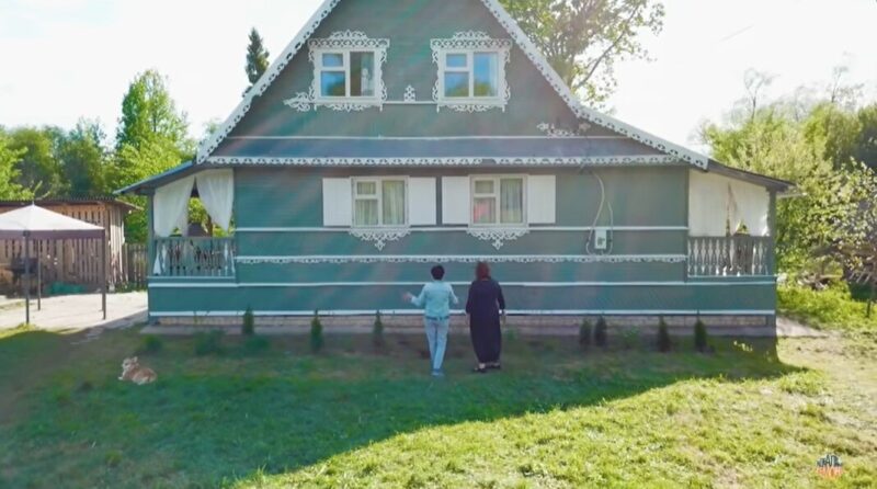 Обновлённый фасад дома, окрашенный в спокойный фисташковый оттенок, выглядит свежо и элегантно.