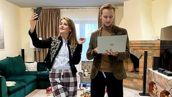 Обеденный стол на восемь персон, освещённый стильными подвесными светильниками.