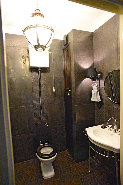 Кухонная зона с необычной люстрой из столовых приборов, создающей уникальный акцент.