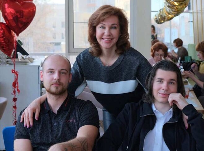 Елена Кутьина в окружении молодых людей, предположительно сыновей